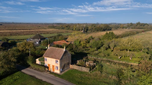 An aerial view of Cladium and Wicken Rose Cottage, with the Visitor Centre and Wicken Fen Nature Reserve in the background, Cambridgeshire